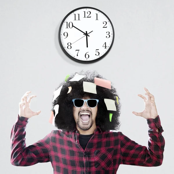 Frustrado hombre afro con reloj de pared — Foto de Stock