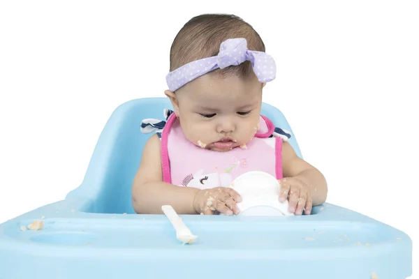 Engraçado bebê menina comer comida na cadeira — Fotografia de Stock