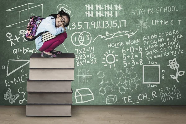 Kid se agacha en los libros con garabatos en clase —  Fotos de Stock