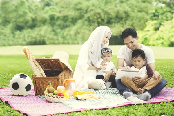 穆斯林家庭在公园里的数字平板电脑 — 图库照片