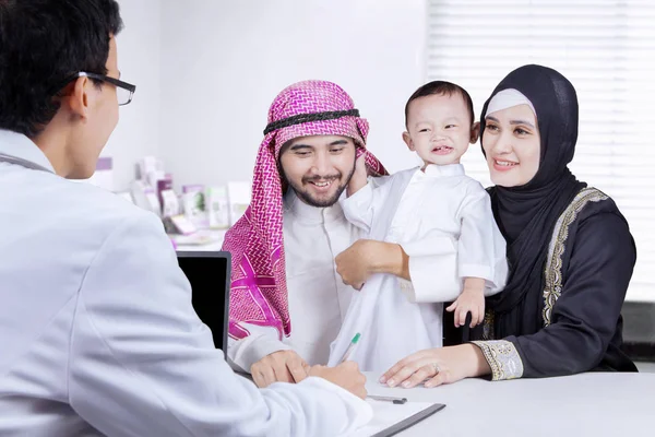 Pediatra con familia árabe en la clínica —  Fotos de Stock