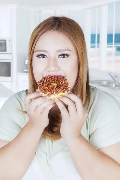 Vrouw donut in de hand te eten — Stockfoto