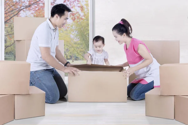Азиатская семья распаковывает дома коробки — стоковое фото