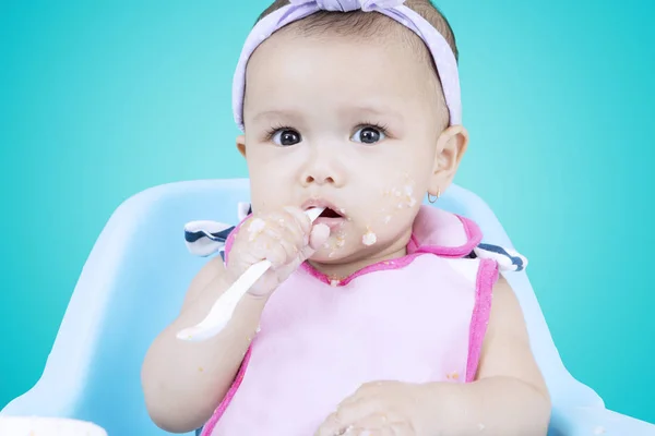 Baby bites a porridge spoon — Stock Photo, Image