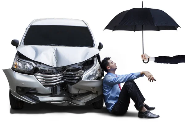 Podnikatel s nabourané auto a deštník — Stock fotografie