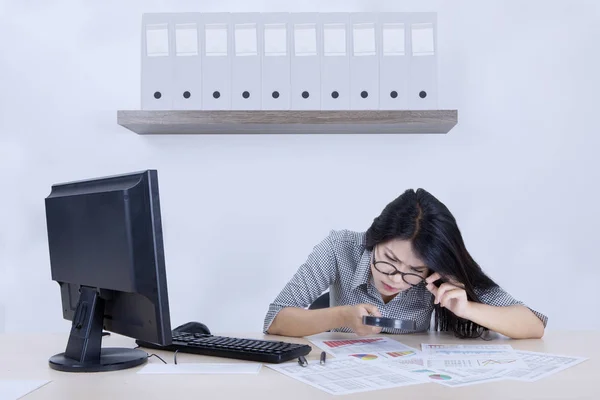 Businesswoman checks a declining chart with magnifier — Stock Photo, Image