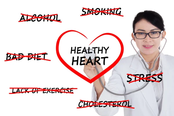 Kvinnliga läkare kontrollera en hjärtsymbol — Stockfoto