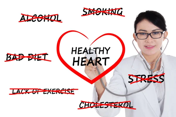 Female doctor checking a heart symbol — Stock Photo, Image