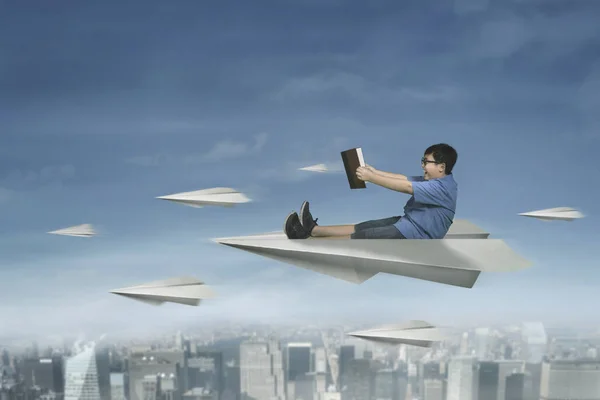 Male student flying with paper airplane — Stock Photo, Image