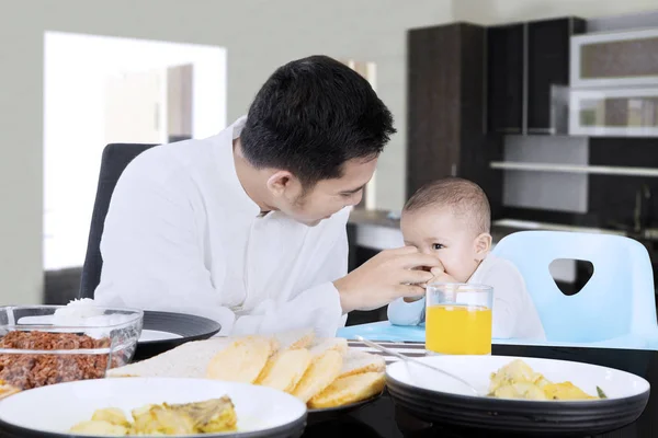 Pai muçulmano alimentando seu bebê — Fotografia de Stock