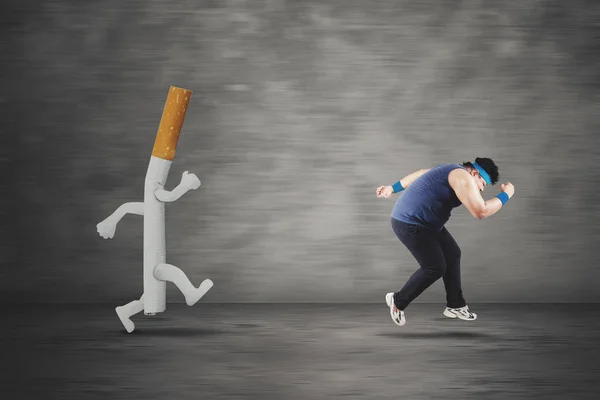 Obese man running with a cigarette — Stock Photo, Image