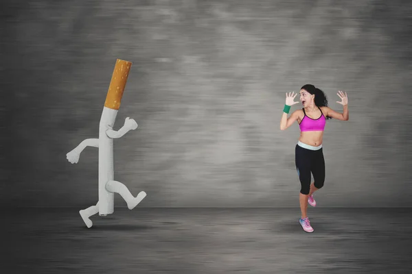 Scared woman running away by a cigarette — Stock Photo, Image