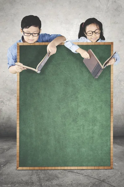 Zwei kleine Schüler hinter einer Tafel — Stockfoto