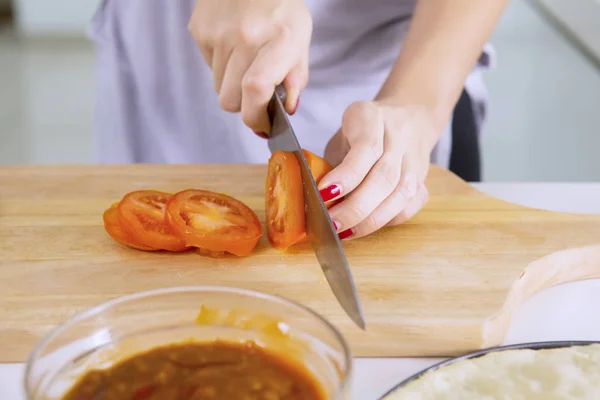 Frau schneidet eine Tomate — Stockfoto