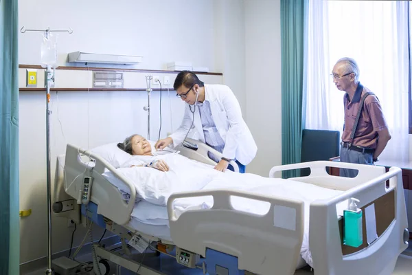 Jovem médico examinando paciente idoso — Fotografia de Stock