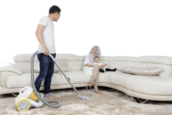 Ung man rengöring mattan med dammsugare — Stockfoto