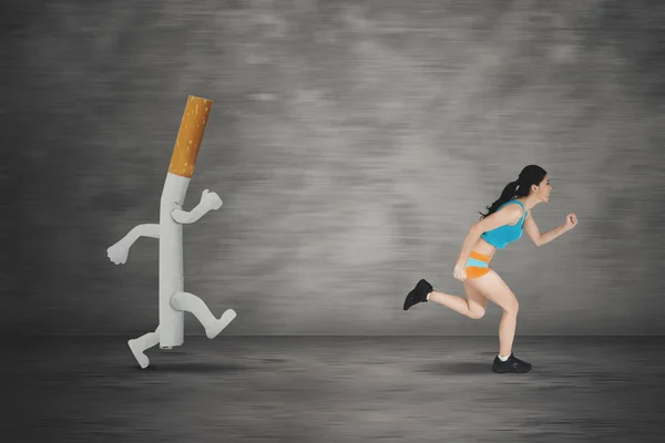 Young woman running away by a cigarette — Stock Photo, Image