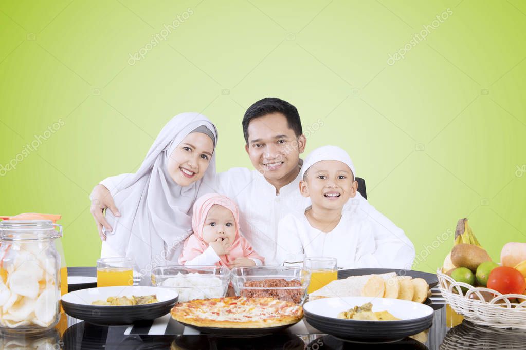 Muslim family smiling at dining table 