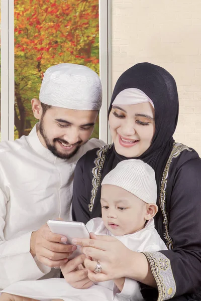 Arabian parents and child hold cellphone — Stock Photo, Image