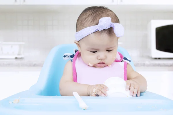Aantrekkelijke baby eet puree in keuken — Stockfoto