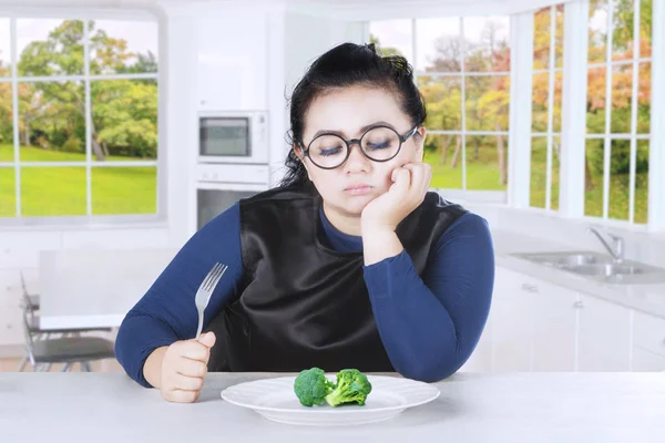 Tyk kvinde føler keder sig med broccoli - Stock-foto