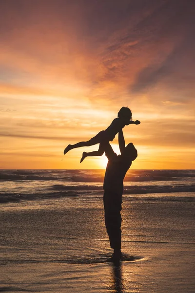 Father lifting up his daughter on beach — Stock Photo, Image