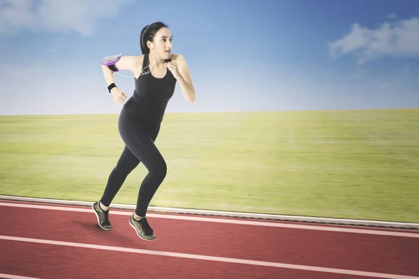 Chica corriendo mientras escucha música — Foto de Stock