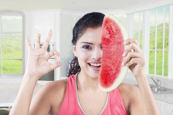 Kvinna som täcker hennes ansikte med vattenmelon — Stockfoto