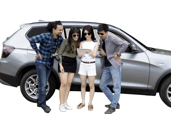 Jovem mulher e amigos se apoiam em um carro — Fotografia de Stock