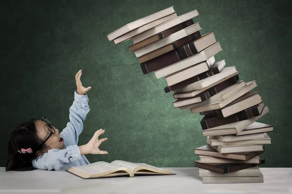 Estudante bonito com pilha de livros caindo — Fotografia de Stock