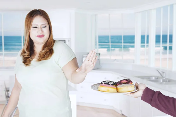 Dikke vrouw met donuts thuis — Stockfoto