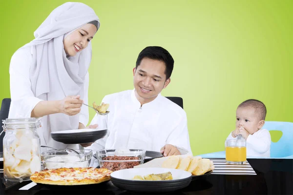 Mulher muçulmana serve comida para a família — Fotografia de Stock