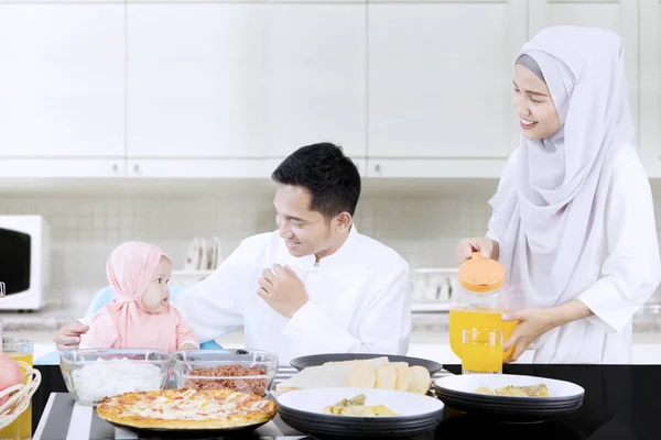 Familia sonriente comiendo juntos en la cocina —  Fotos de Stock