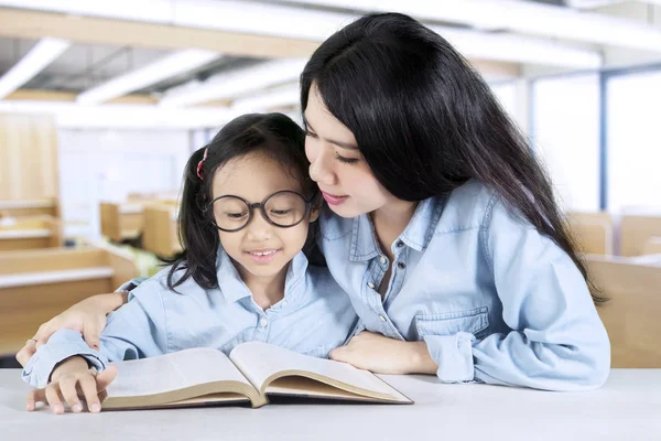 Učitel čte knihu s její student — Stock fotografie
