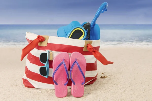 Bolsa de mulher com item de praia na areia — Fotografia de Stock