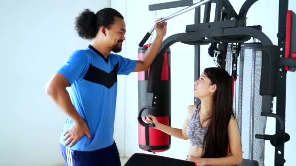 Женщина разговаривает со своим тренером в спортзале — стоковое видео