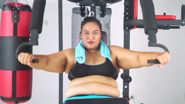 Fat woman doing exercise on gym equipment — Stock Video