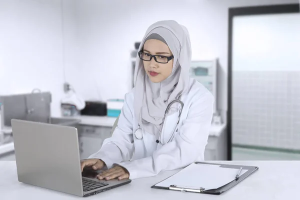 Asian muslim doctor working in clinic — Stock Photo, Image
