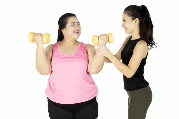 Dikke vrouw doen oefening met trainer — Stockfoto