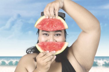 Sahilde karpuz ile obez kadın 