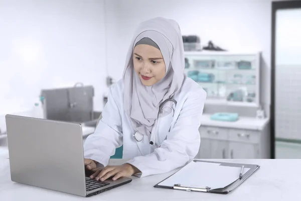 Female muslim doctor works with laptop — Stock Photo, Image