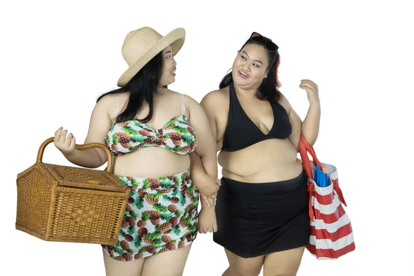 Übergewichtige Frauen gehen mit Picknickutensilien spazieren — Stockfoto