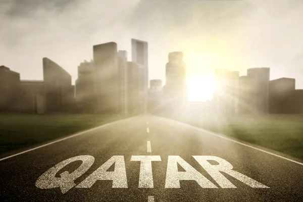 Qatar palabra en el camino vacío — Foto de Stock