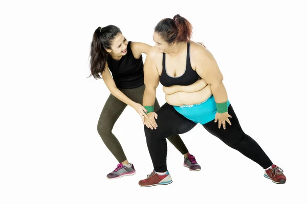 Entrenador ayudando a la mujer gorda haciendo ejercicio — Foto de Stock