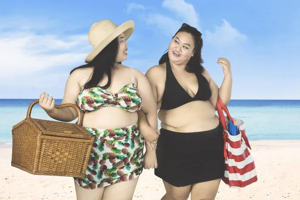 Twee vrouwen lopen op strand overgewicht — Stockfoto