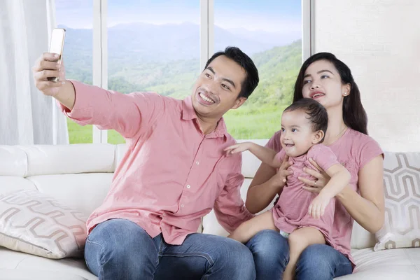 Deux parents et leur fille prenant des photos selfie — Photo