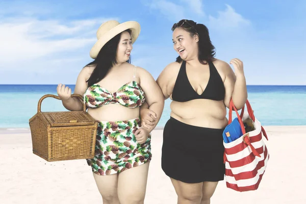 Twee vrouwen lopen op zand strand — Stockfoto