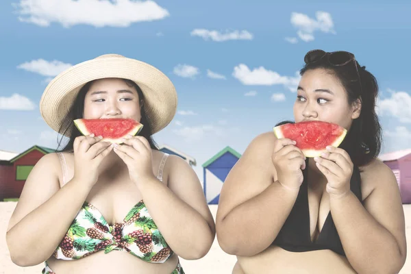 Women eating watermelon near cottage — Stock Photo, Image