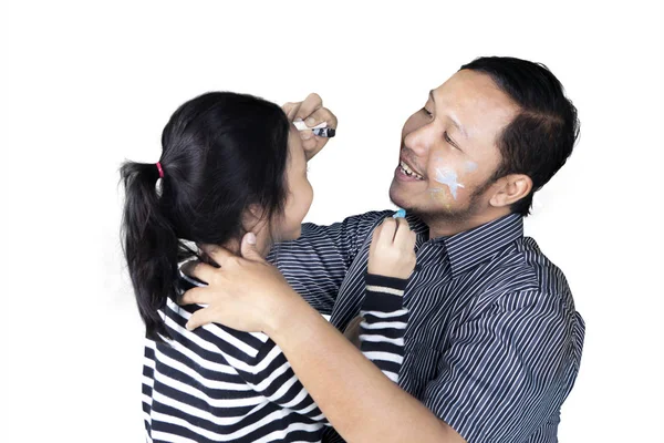 Νεαρός πατέρας ζωγραφική ένα πρόσωπο της κόρης του — Φωτογραφία Αρχείου