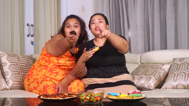 Избыточный вес женщины едят нездоровую пищу на диване — стоковое видео
